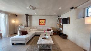 a living room with a white couch and a table at Refuge des Sottais in Burg-Reuland