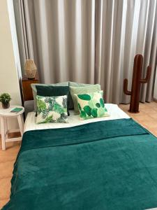 a bedroom with a bed with green sheets and pillows at CASA MACA sea view & beach front in Puerto del Carmen +40 photos