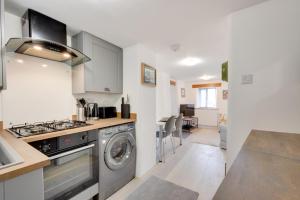 a kitchen with a stove and a washing machine at 1 Bed in Ashover oc-dclhil in Ashover