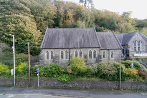 an old stone church with a black roof at Modern Town House Bangor City Centre in Bangor