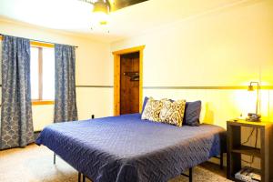 a bedroom with a bed with a blue comforter at Charming Ski Chalet at Powderhorn Mountain in Bessemer