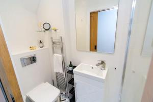 a white bathroom with a sink and a mirror at Modern Town House Bangor City Centre in Bangor +16 photos