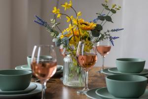 a table with glasses of wine and a vase of flowers at 2 Bed in Matlock oc-dcbeau in Crich +8 photos