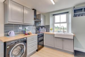a kitchen with white cabinets and a washer and dryer at 2 Bed in Matlock oc-dcbeau in Crich
