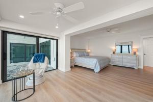 a bedroom with a bed and a chair and a table at Mariner Pointe 941 in Sanibel +62 photos