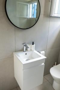 a bathroom with a white sink and a mirror at Spitaki by the Sea in Paralimni +16 photos