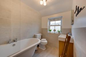 a bathroom with a tub and a toilet and a sink at 1 Bed in Crakehall oc-ds955 in Crakehall +15 photos