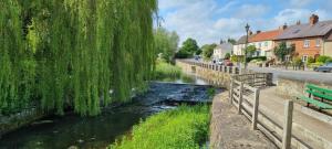 a river with a weeping willow tree hanging over it at 1 Bed in Crakehall oc-ds955 in Crakehall