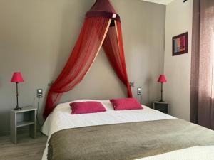a bedroom with a large bed with red curtains at Chambres d'hôtes L'Ecrin des Saveurs in Schwenheim