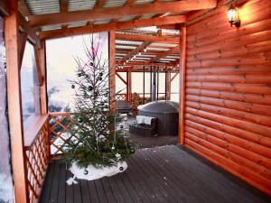 a room with a christmas tree on a deck at Kundziņi in Bīriņi