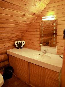 a bathroom with a sink in a wooden wall at Kundziņi in Bīriņi +235 photos