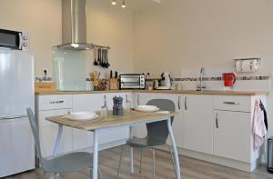 a kitchen with white cabinets and a table with chairs at Champ De Foire in Sussac