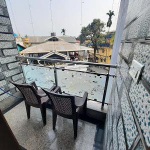 a balcony with two chairs and a swimming pool at Surakha INN LLP in Siliguri