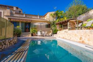 a house with a swimming pool in front of a house at Es Raco in Caimari