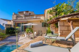 a villa with a swimming pool and a house at Es Raco in Caimari