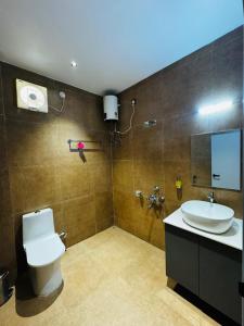 a bathroom with a toilet and a sink and a mirror at Mannat Hotel in Tezpur