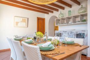a dining room with a wooden table and chairs at Es Raco in Caimari