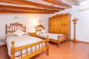 a bedroom with two beds and a wooden cabinet at Es Raco in Caimari +28 photos