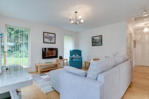 a living room with a white couch and a blue chair at 1 Bed in Belford oc-nb677 in Belford