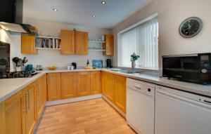 a large kitchen with wooden cabinets and a microwave at 1 Bed in Belford oc-nb677 in Belford +6 photos