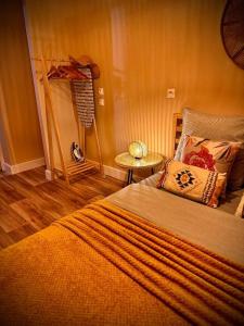 Bohème - Maison entièrement privée في سان جان دي براي: غرفة نوم بها سرير وطاولة جانبية +5 صور
