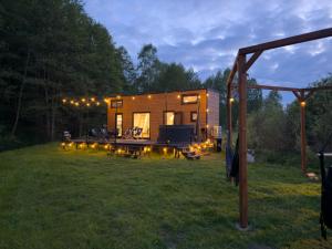 ein winziges Haus in einem Garten bei Nacht in der Unterkunft Tiny Silent House River in Zblewo