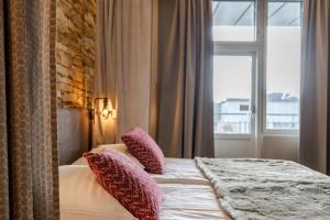 a bedroom with a bed with pillows and a window at Santa's Hotel Santa Claus in Rovaniemi