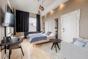 a bedroom with a bed and a couch and a tv at Santa's Hotel Santa Claus in Rovaniemi