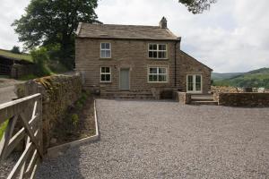 an old stone house with a fence in front of it at 3 Bed in Low Row oc-ds1030 in Gunnerside