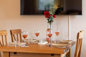 a wooden table with wine glasses and a vase with red flowers at 3 Bed in Bainbridge oc-ds1026 in Bainbridge +10 photos