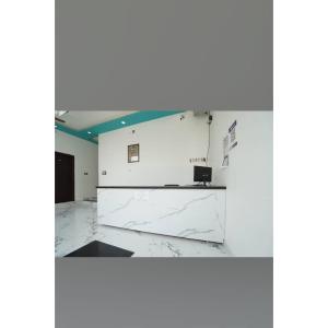 an empty room with a white wall and marble floor at Awadh Ram Hotel in Ayodhya