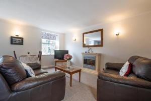 a living room with two leather couches and a fireplace at 1 Bed in Gunnerside oc-ds1016 in Gunnerside +5 photos