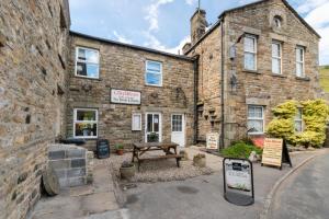 a stone building with a picnic bench in front of it at 1 Bed in Gunnerside oc-ds1016 in Gunnerside