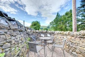 a patio with a table and chairs and a stone wall at 2 Bed in Hawes oc-ds052 in Hawes