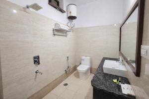 a bathroom with a white toilet and a sink at Hotel Gajender Niwas Sun City A Boutique Stay in Jodhpur +22 photos