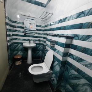 a bathroom with a toilet and a sink at Surakha INN LLP in Siliguri +20 photos