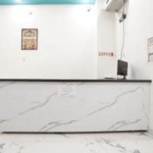 a counter in a room with a picture on the wall at Awadh Ram Hotel in Ayodhya
