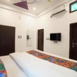 a bedroom with a bed and a tv on the wall at Awadh Ram Hotel in Ayodhya