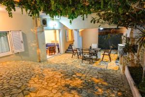 a house with a stone patio with a table and chairs at White Villa in Xylokastro
