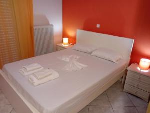 a bedroom with a bed with towels on it at White Villa in Xylokastro