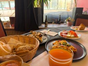 a table with plates of food and a basket of bread at Hotel Wilder Mann in Steinach am Brenner