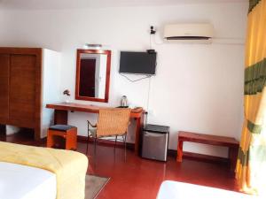 a room with a desk and a table with a mirror at Sunset Araliya by Diyakawa in Aluthgama