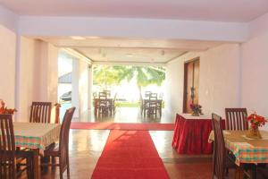a dining room with tables and chairs and a red carpet at Sunset Araliya by Diyakawa in Aluthgama