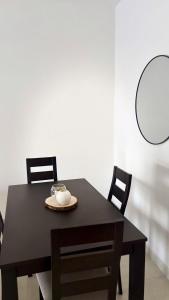 a black table with chairs and a plate on it at Appartement Bissau in Dakar