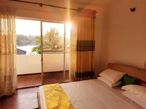 a bedroom with a bed and a large window at Sunset Araliya by Diyakawa in Aluthgama +48 photos