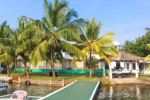 a house with a pool and palm trees next to a table at Sunset Araliya by Diyakawa in Aluthgama