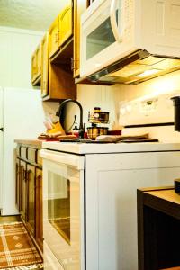 a kitchen with a white stove top oven and cabinets at Snowbound Bliss at Powderhorn Mountain in Bessemer