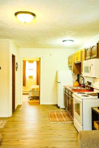 a kitchen with white appliances and wooden floors at Snowbound Bliss at Powderhorn Mountain in Bessemer