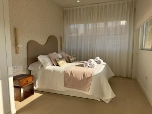 a bedroom with a large white bed with a window at Apartamentos Las Mereras in Fuente Palmera