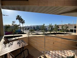 a balcony with a view of a street and palm trees at Apartamentos Las Mereras in Fuente Palmera